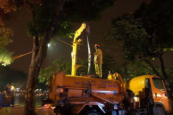 Công nhân dầm mưa lạnh suốt đêm nạo vét Hồ Gươm